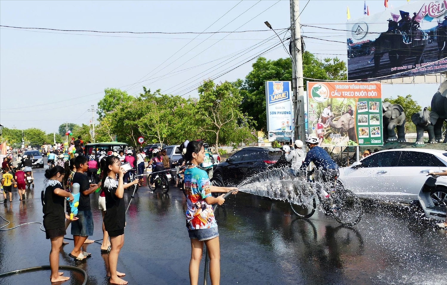 Người bên đường vui vẻ té nước mát và chúc phúc cho đoàn rước