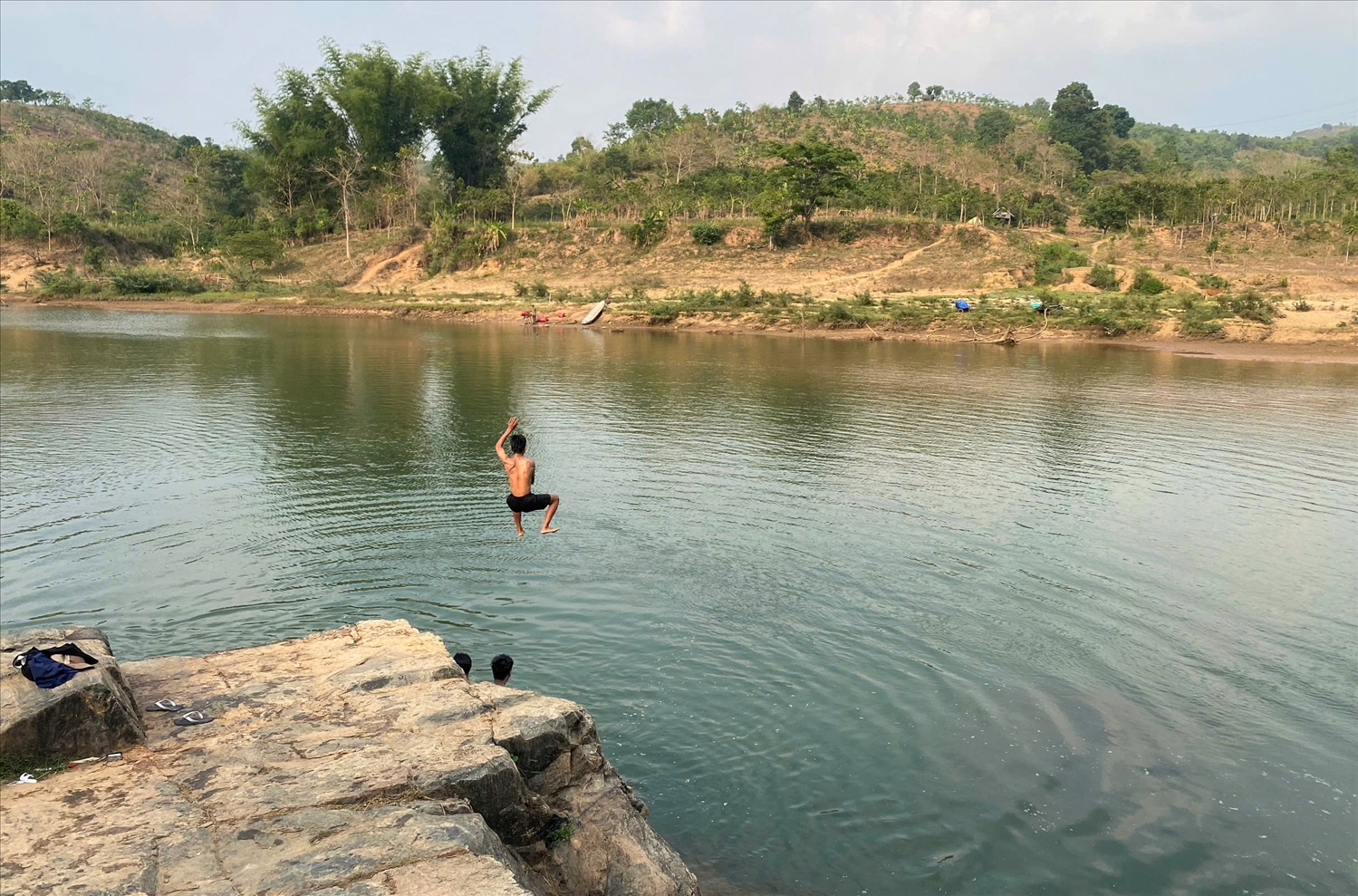 Nhiều thanh thiếu niên leo lên những tảng đá cao rồi nhảy tự do xuống lòng sông Đăk Bla. (Ảnh: Ngọc Chí)