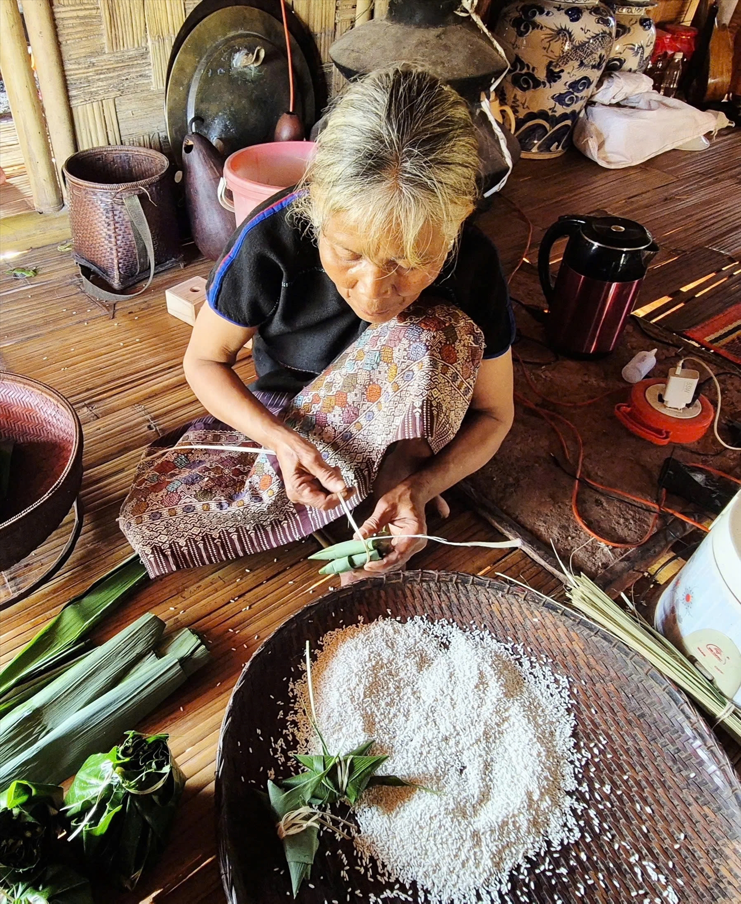 Bà Hồ Thị Doanh đang tỉ mỉ buộc bánh Aquat (Ảnh: Kô Kăn Sương)