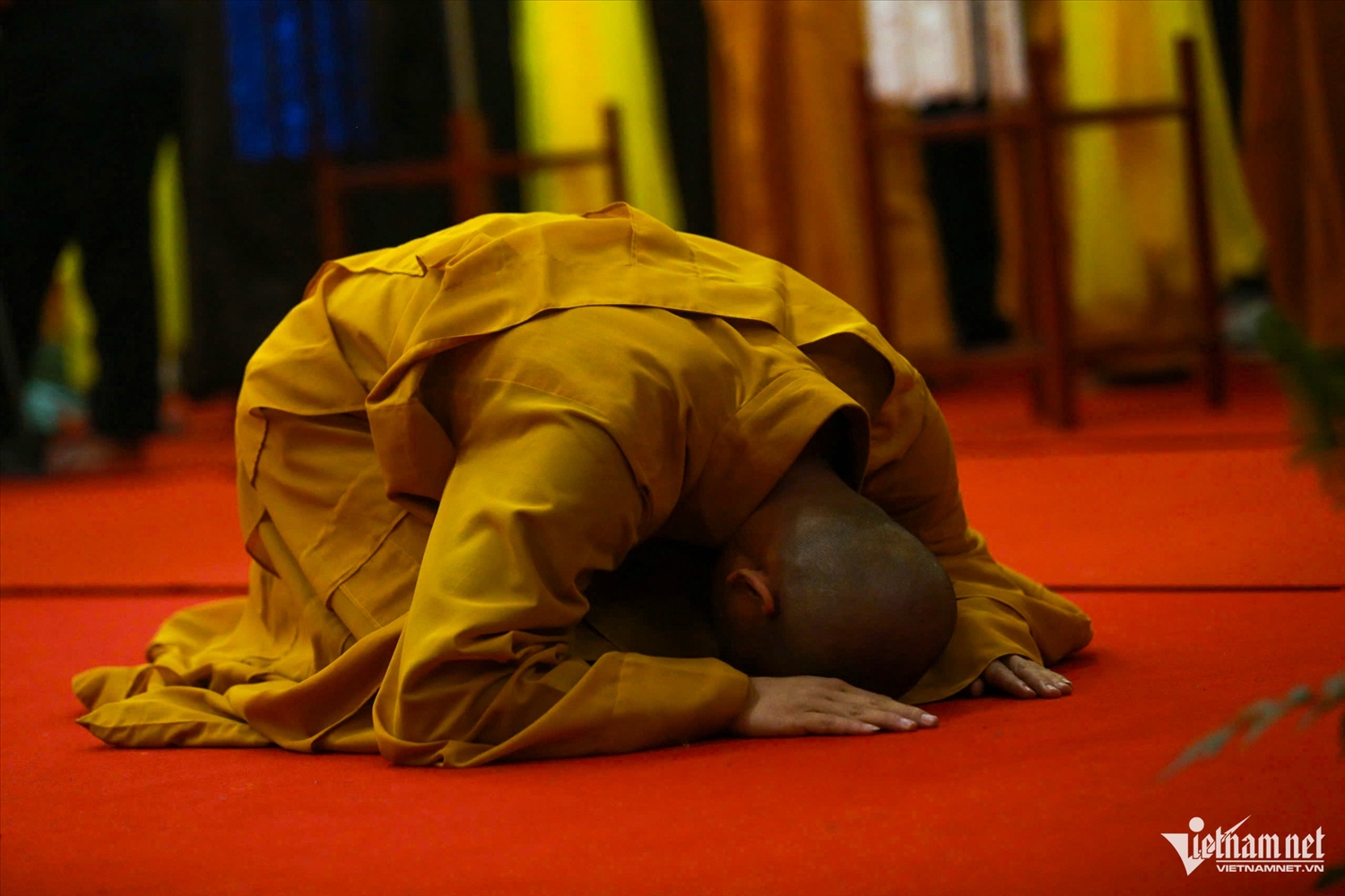 Một nhà sư thành kính quỳ lạy trước kim quan Trưởng lão Hòa thượng, bày tỏ lòng tri ân và niềm tiếc thương sâu sắc