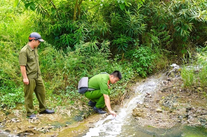 Lực lượng công an lấy mẫu nước tại suối Dòng Sông (xã Thạch Quảng, Thanh Hóa) để xác định nguyên nhân sự cố môi trường.