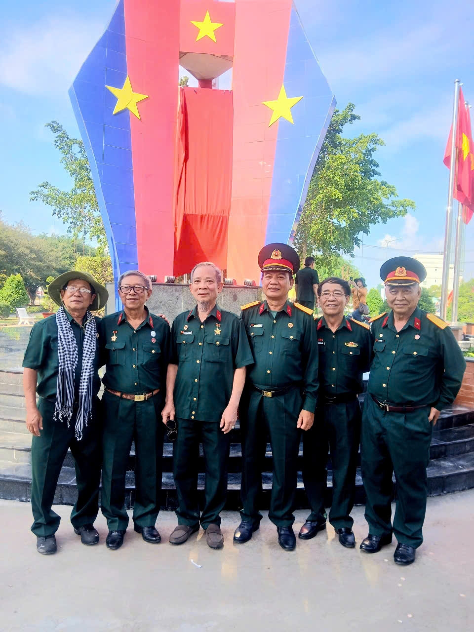 Tác giả Nguyễn Vũ Điền (người thứ hai từ phải sang) cùng đồng đội bên Bia Chiến thắng của Trung đoàn 174 tại thành phố Tân An, tỉnh Long An cũ (nay là tỉnh Tây Ninh)