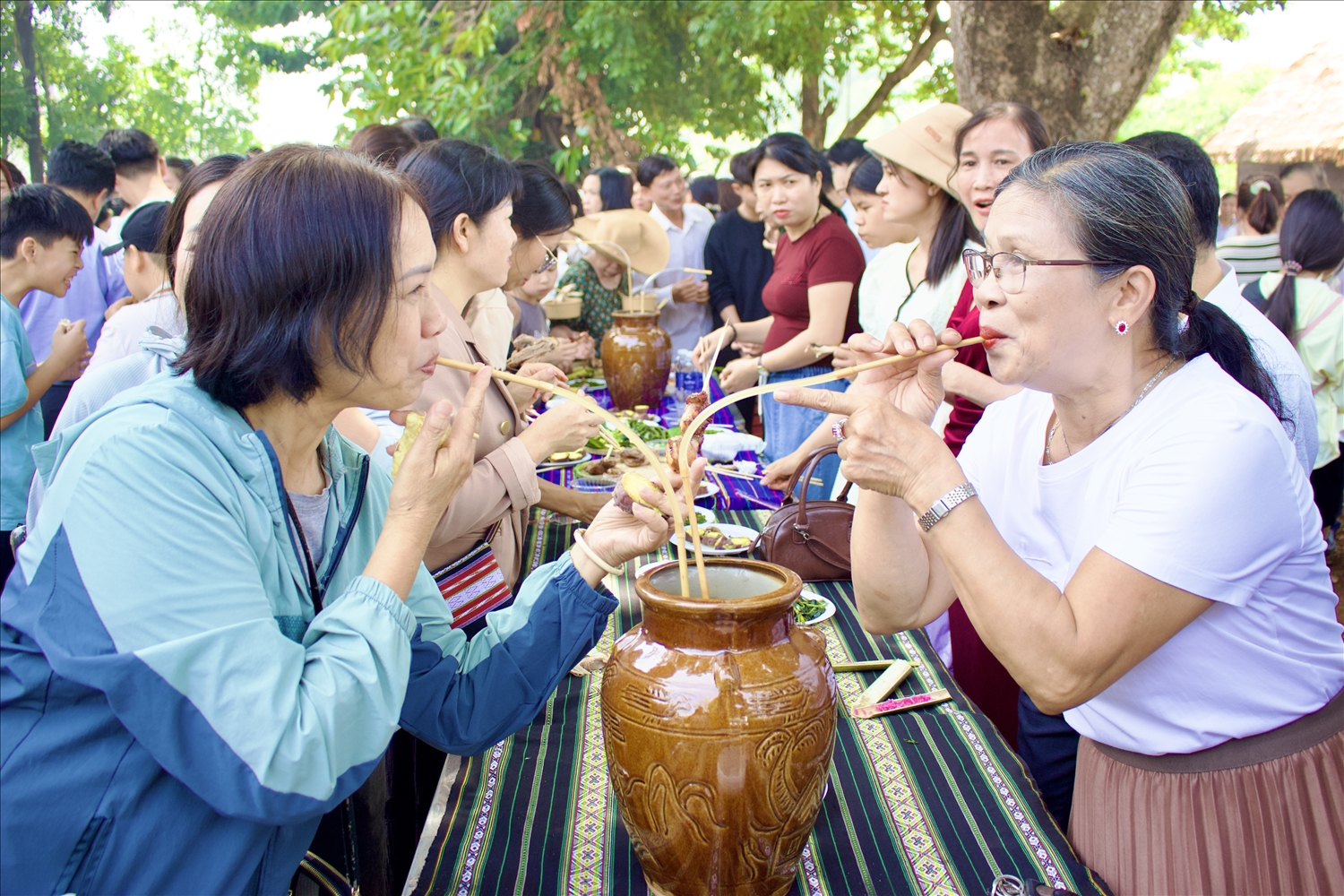 Người dân, du khách thưởng thức rượu ghè truyền thống của đồng bào Gia Rai