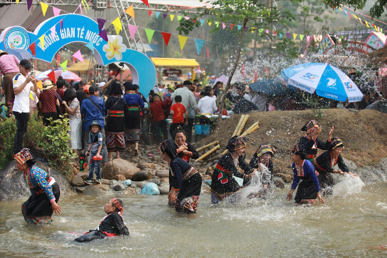 Người dân và du khách tham gia té nước cầu may (Ảnh. Trần Nhâm)