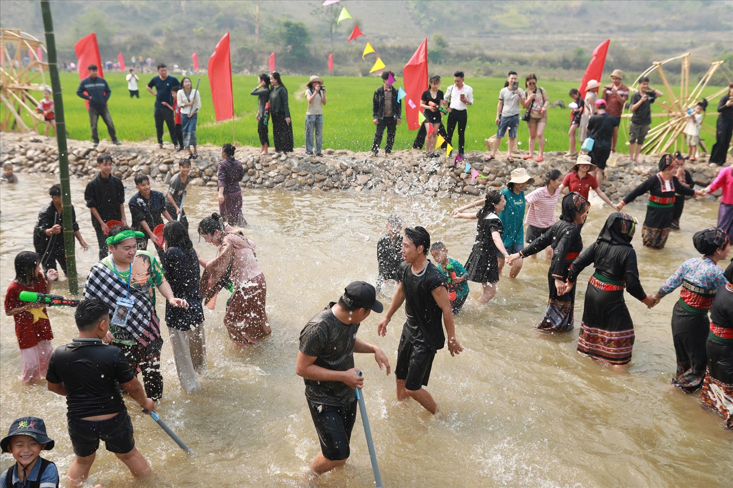 Người dân và du khách tham gia té nước cầu may (Ảnh. Trần Nhâm)