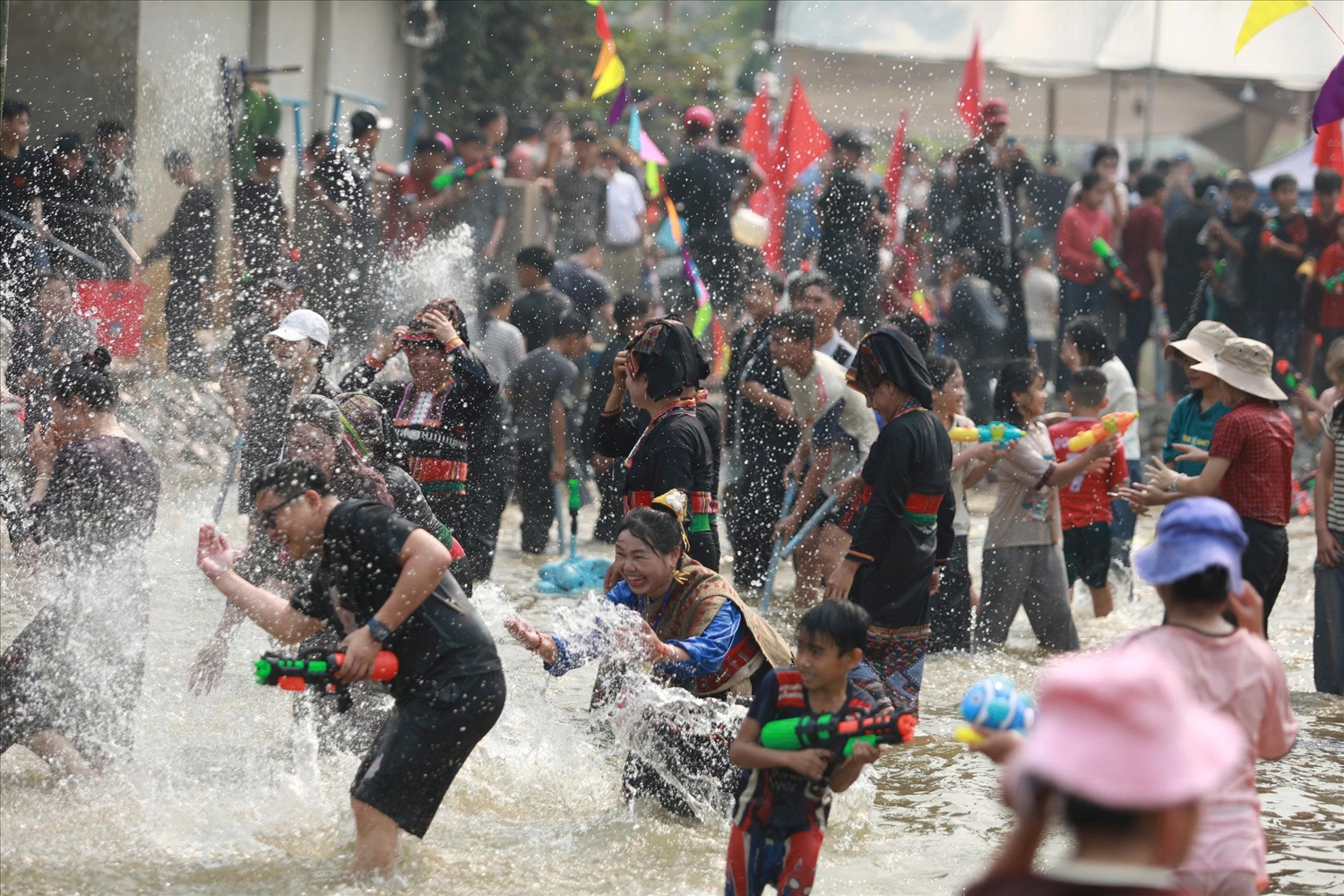 Người dân và du khách tham gia té nước cầu may (Ảnh. Trần Nhâm)