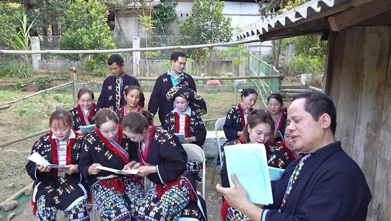 Ông Triệu Văn Lĩu dạy chữ Dao cho người dân.