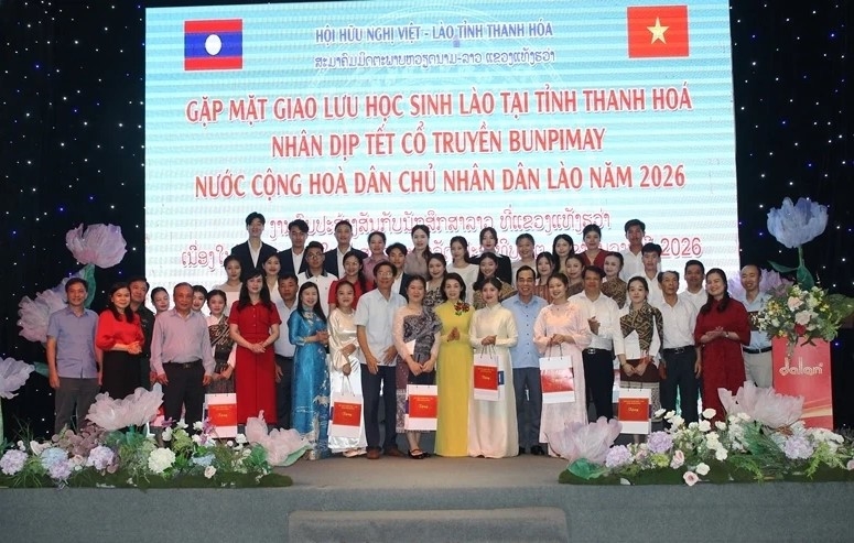Các đại biểu chụp ảnh lưu niệm với lưu học sinh Lào.