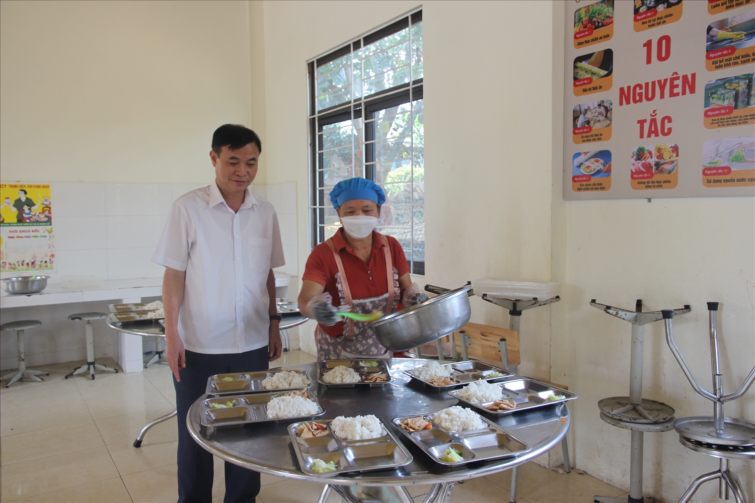 Thầy giáo Ngô Văn Hướng kiểm tra chất lượng bữa ăn cho học sinh của trường (Ảnh Trọng Bảo)