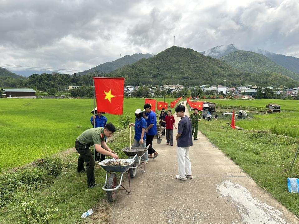 Công an xã Quang Chiểu phối hợp với Nhân dân địa phương dựng cột, treo cờ Tổ quốc dọc tuyến đường vào trung tâm xã.