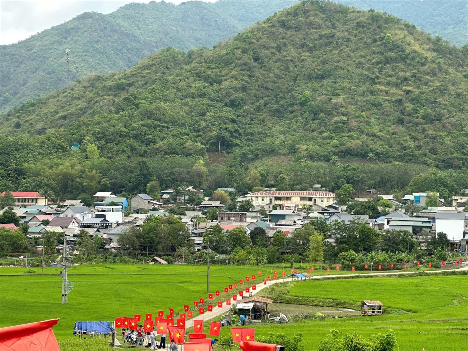 Tuyến “Đường cờ Tổ quốc” uốn dài qua cánh đồng xanh mướt, tạo điểm nhấn rực rỡ cho diện mạo nông thôn xã biên giới Quang Chiểu (Thanh Hóa).