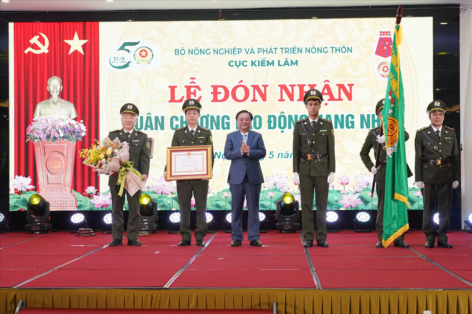  Bộ trưởng Bộ NN&PTNT Lê Minh Hoan trao Huân chương Lao động hạng Nhất tặng Cục Kiểm lâm và gắn Huân chương lên cờ truyền thống của lực lượng kiểm lâm.