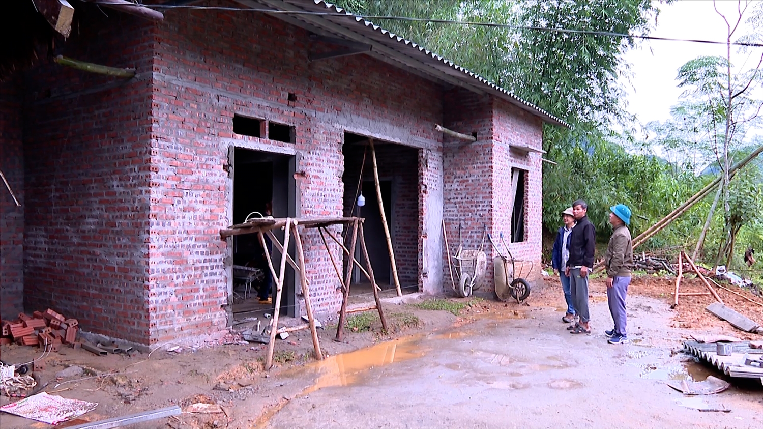 Gia đình anh Lạc Thế Tuyên ở xã Việt Hồng, huyện Trấn Yên trước ngôi nhà mới đang được hoàn thiện bằng sự hỗ trợ tiền xã hội hóa, cũng như của anh em trong gia đình