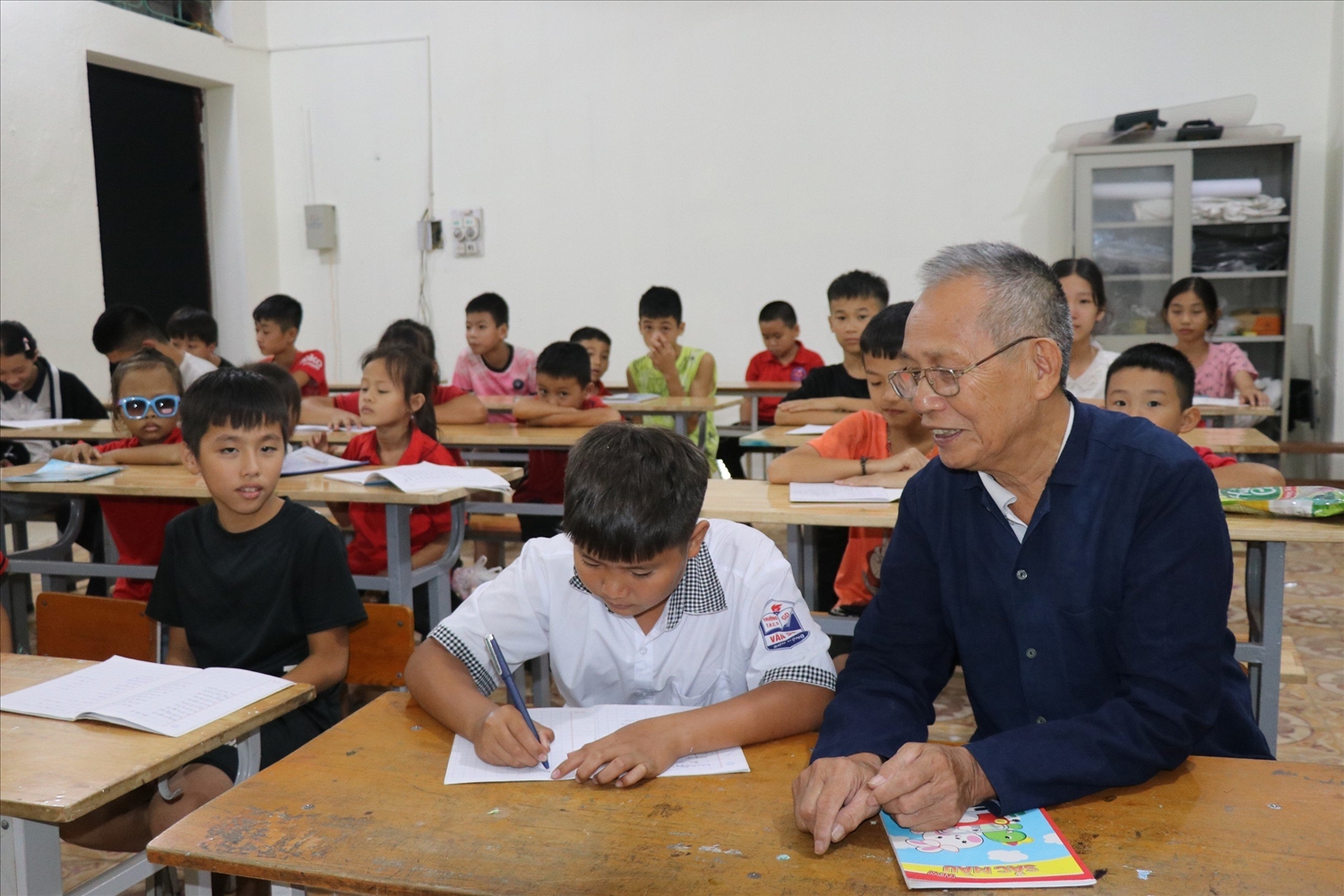 Già làng Đàm Xuân Tình tình nguyện dạy tiếng dân tộc Cao Lan và Sán Chí cho con em đồng bào dân tộc.