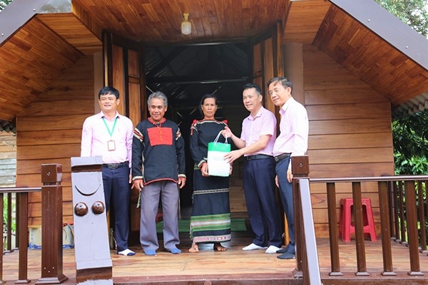 Phó Tổng Giám đốc Ngân hàng CSXH Hoàng Minh Tế và đại diện chi nhánh Ngân hàng CSXH tỉnh Đắk Lắk tặng quà cho hộ vay vốn