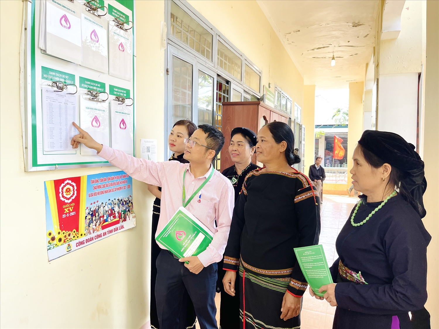 Can bộ Ngân hàng CSXH huyện Krông Năng, Đắk Lắk hướng dẫn người dân các chương trình vay vốn tại điểm niêm yết ở Điểm giao dịch xã 