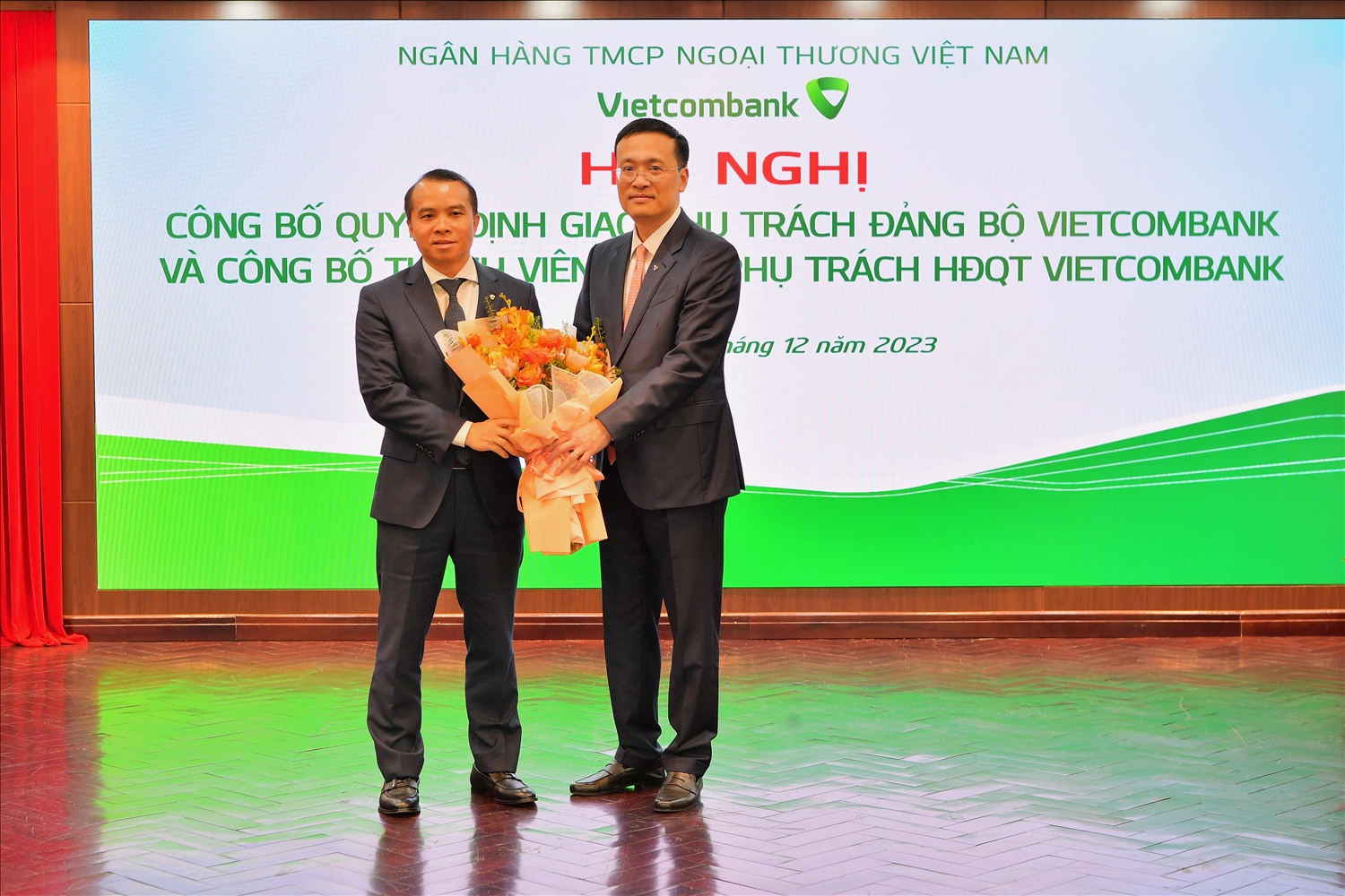 Đ/c Phạm Quang Dũng - Bí thư Đảng ủy, Chủ tịch HĐQT Vietcombank (bên phải) tặng hoa chúc mừng đ/c Đỗ Việt Hùng