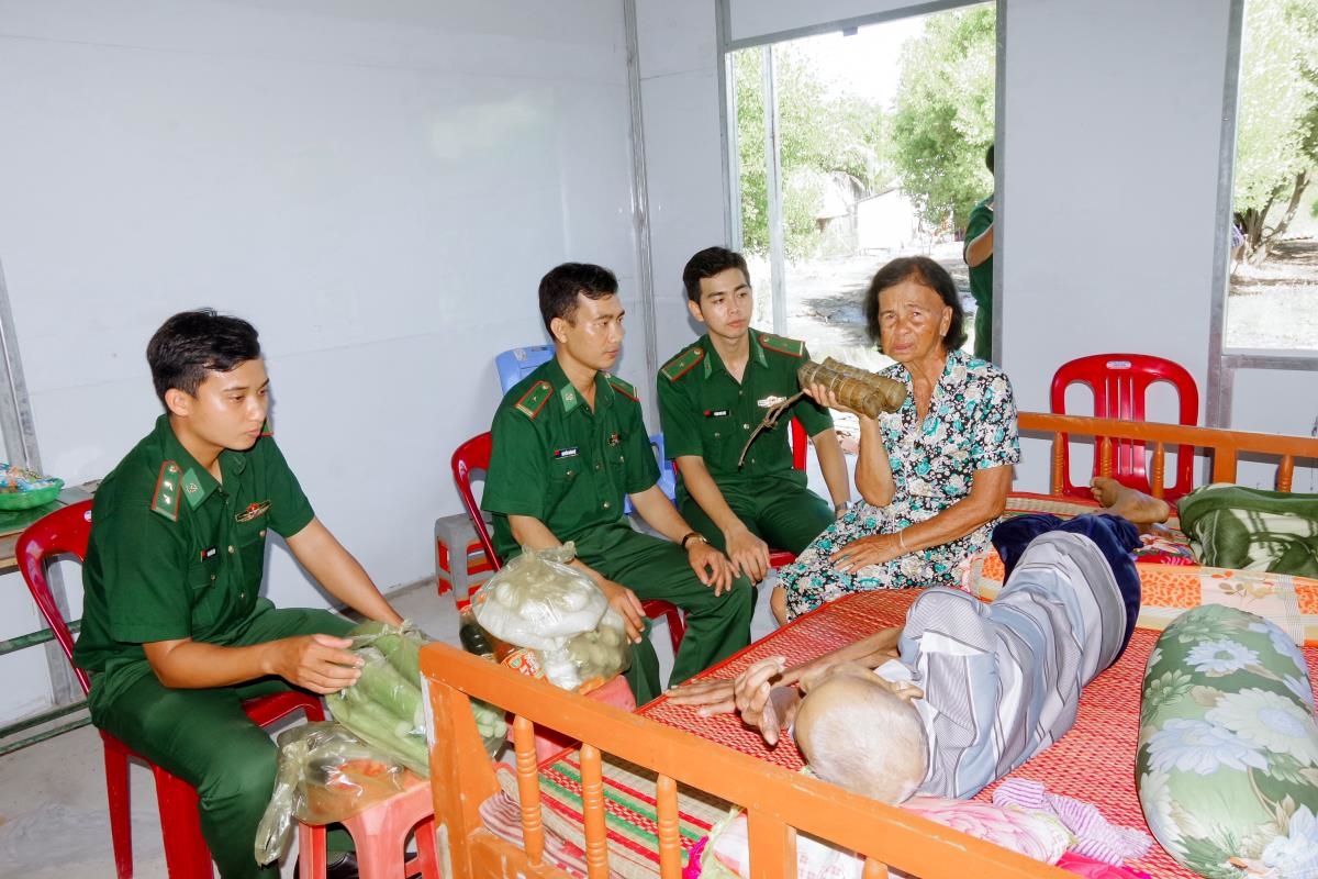 Cán bộ Đồn Biên phòng Lai Hòa xuống tận nhà để trao quà cho hộ gia đình bà Lâm Thị Lôi. Ảnh: Văn Long