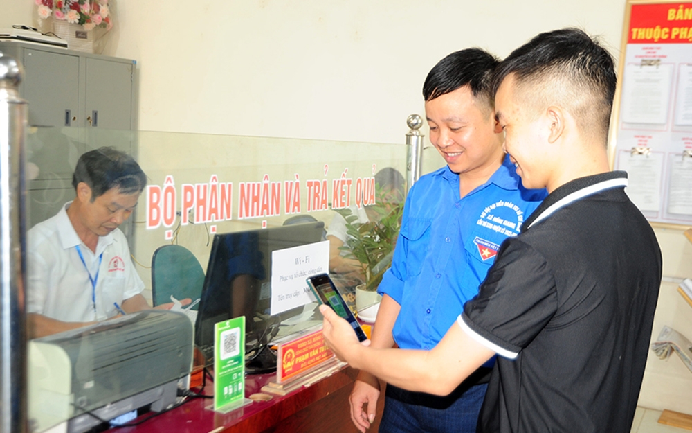 Đoàn viên thanh niên xã Hồng Giang (Lục Ngạn) hướng dẫn người dân thanh toán bằng mã QR-code