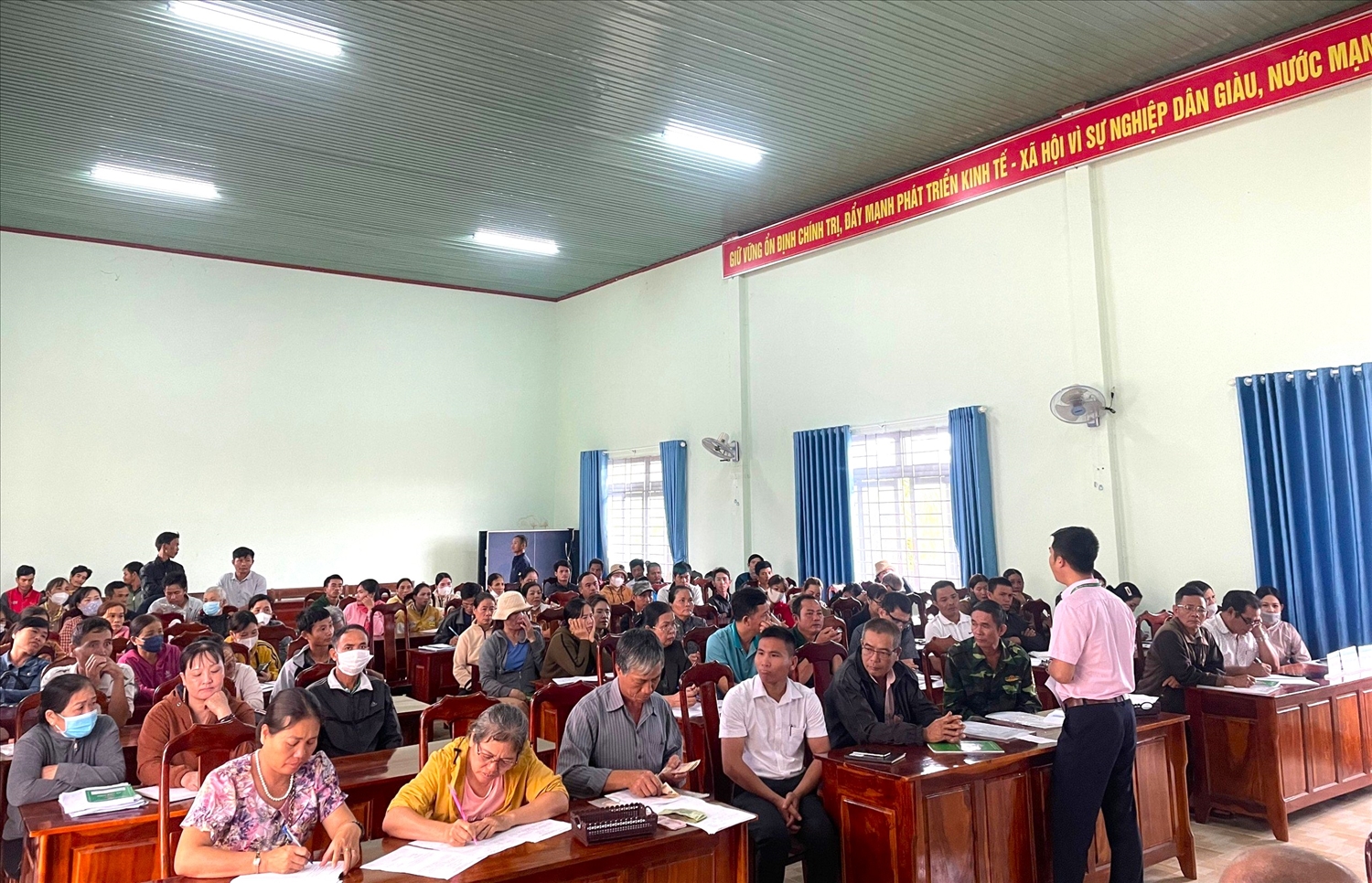 Cán bộ NHCSXH huyện Đắk Mil hướng dẫn người dân tại giao dịch tại xã Đắk Gằn.