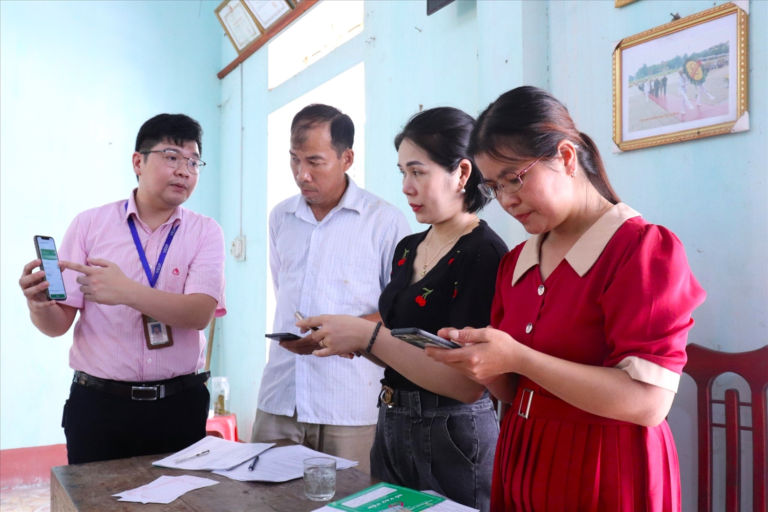Cán bộ NHCSXH huyện Yên Sơn hướng dẫn người dân cách sử dụng ứng dụng Mobie Banking