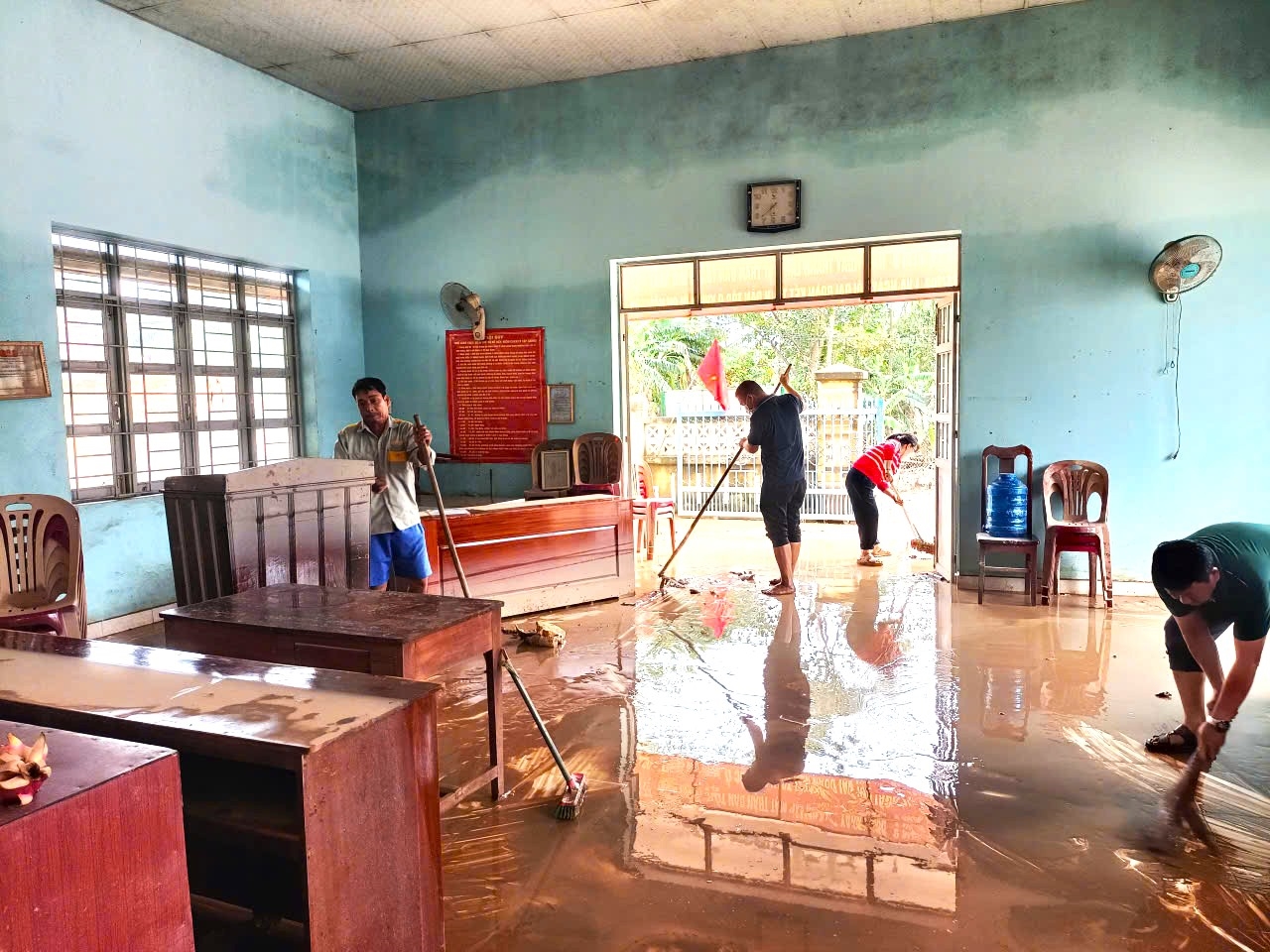 Cán bộ Phòng giao dịch NHCSXH Đông Hòa (Đắk Lắk) cùng cán bộ xã dọn dẹp sau lũ