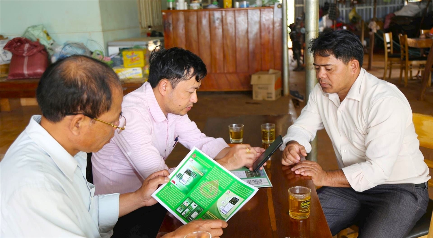 Cán bộ NHCSXH huyện Tuy Đức (Đắk Nông) hỗ trợ chuyển số cho người dân vay vốn