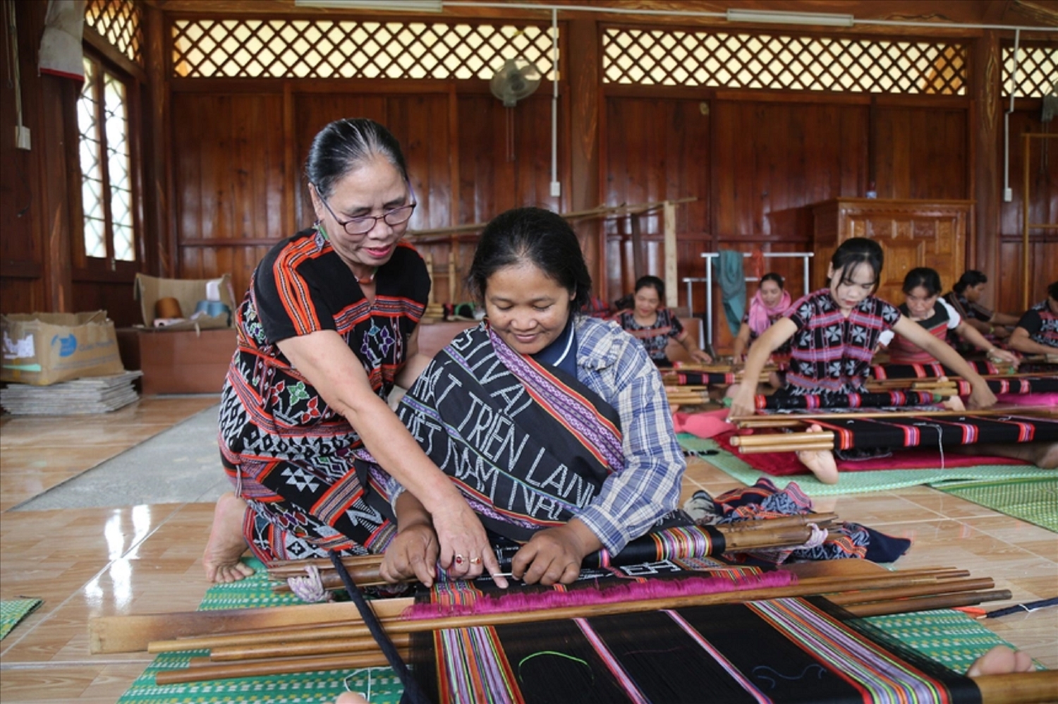 Nghệ nhân Mai Thị Hợp hướng dẫn các thành viên dệt Zèng.