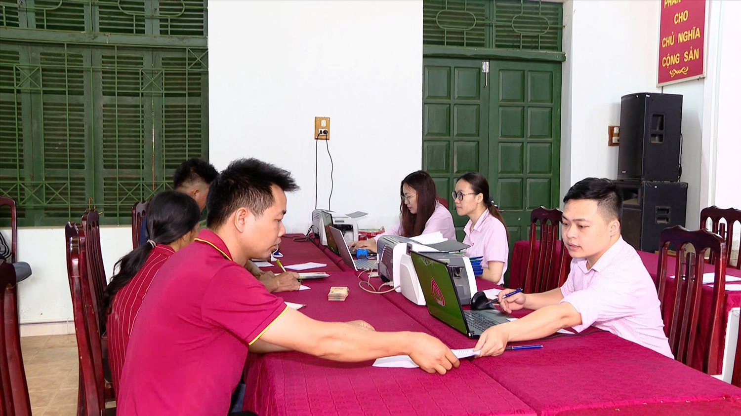 Cán bộ NHCSXH huyện Lâm Bình hướng dẫn người dân trên địa bàn huyện tại điểm giao dịch xã.