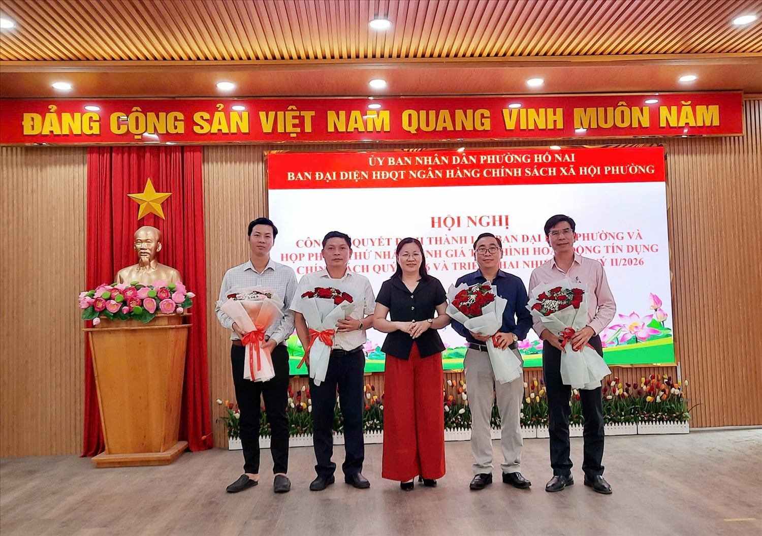 Phó Bí thư thường trực Đảng ủy Hố Nai Đỗ Thị Hòa Bình tặng hoa chúc mừng Ban đại diện HĐQT NHCSXH Hố Nai (Đồng Nai)