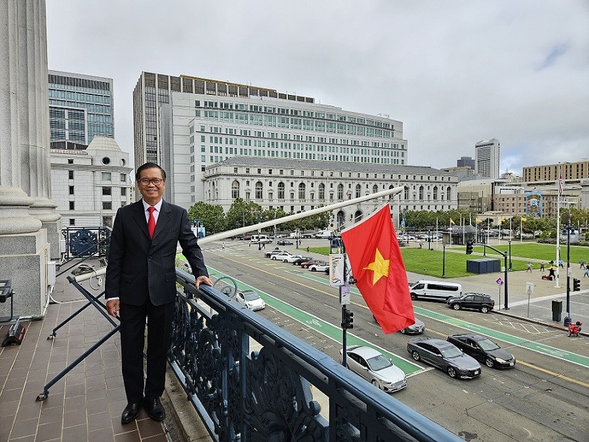 Tổng lãnh sự Hoàng Anh Tuấn bên lá cờ Tổ quốc tung bay trước Tòa Thị chính San Francisco.