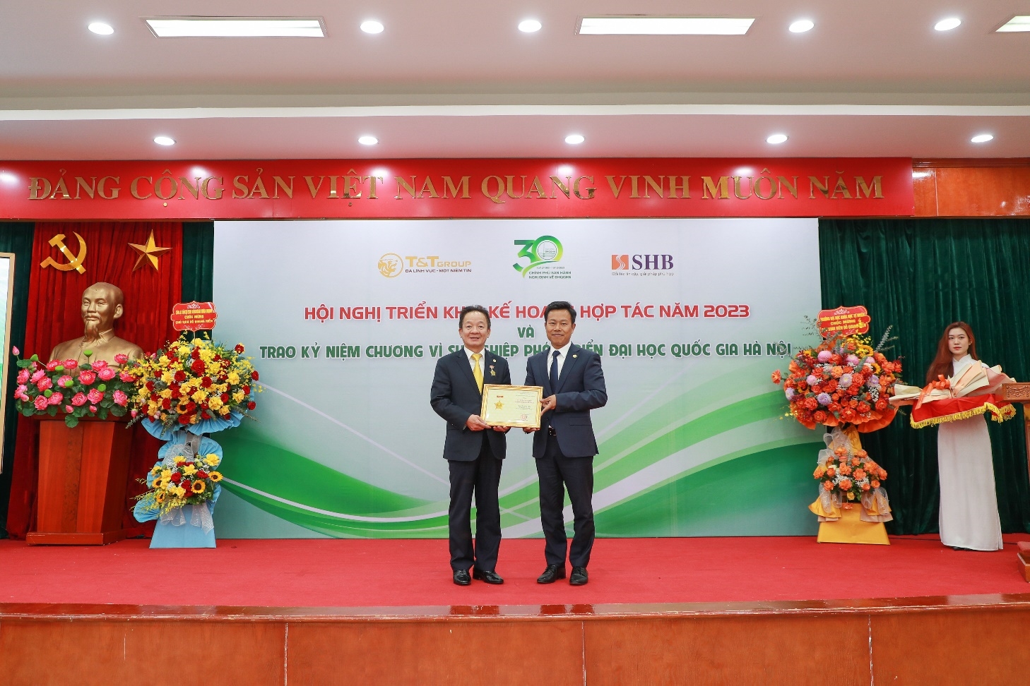 GS.TS Lê Quân (bên phải) trao kỷ niệm chương vì sự nghiệp phát triển ĐHQGHN cho doanh nhân Đỗ Quang Hiển